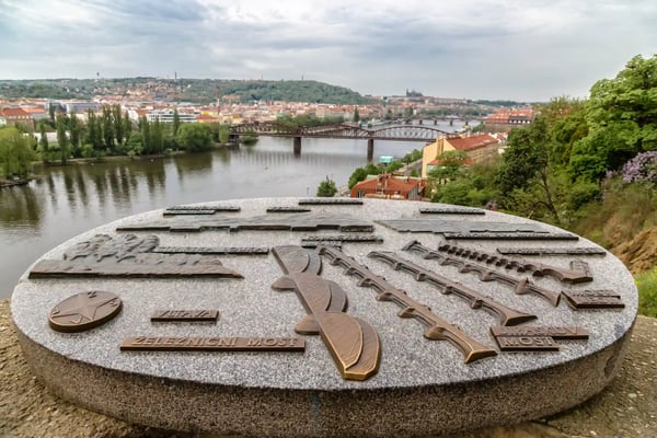 city views and a large granite stone with a metal circuit bridges and buildings of prague czech 