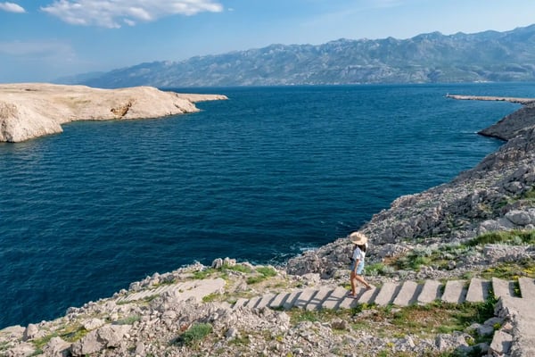 concept picture of traveling woman looking at scenic view by the sea at pag island in croatia 