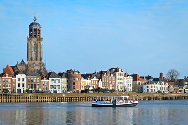 ferry is crossing the river ijssel with a view of the medieval city
