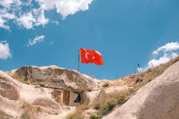 flag of turkey against blue sky with cumulus cloudse