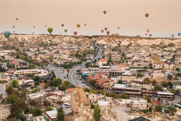 hot air balloon flying over goreme village in cappadocia turkey 