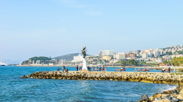 local people enjoying life around signature sculpture at the coastline