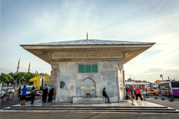 local turkish people walking in uskudar district next to the fountain