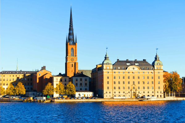 old red brick church on blue water under blue sky