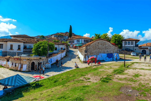 people are strolling thorugh a street inside of the berat castle in 