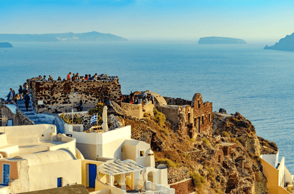 santorini greece sunset in the village of oia tourists looking for the best views