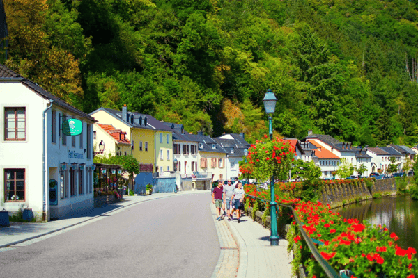 street in the old town of vianden luxembourg in the riverside with red flowers at one side 