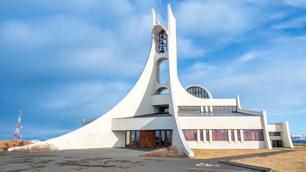 stykkisholmur church on hill at center of town under cloudy blue sky iceland