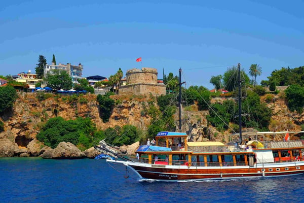 the Hidirlik Tower and a touristic boat in Antalya 