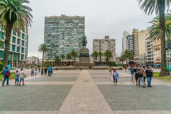 tourists passing the statue of general artigas on the independance square plaza indepencia
