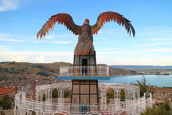 view of lake titicaca and city of puno from the condor hill view point with a huge condor sculpture