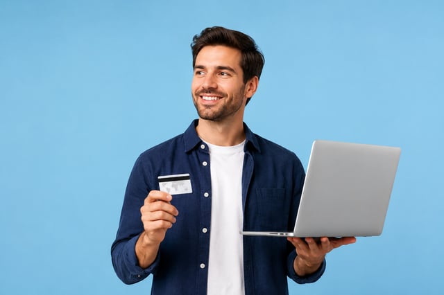 A Guy Holding A Credit Card And Laptop