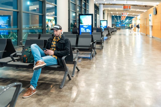Airport Man Using Smartphone In Waiting Area