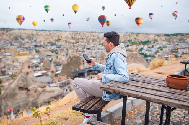 Happy Young Man Watching Hot Air Balloons In Cappadocia Turkey