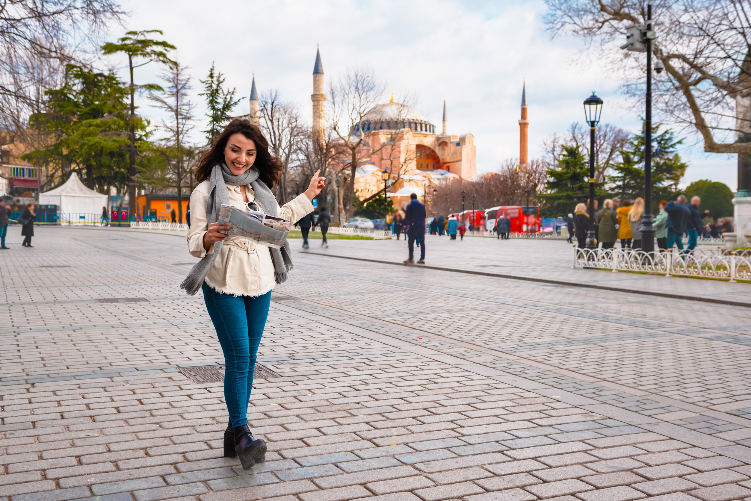 beautiful young girl in fashionable clothes with map walks around and discover city in istanbul