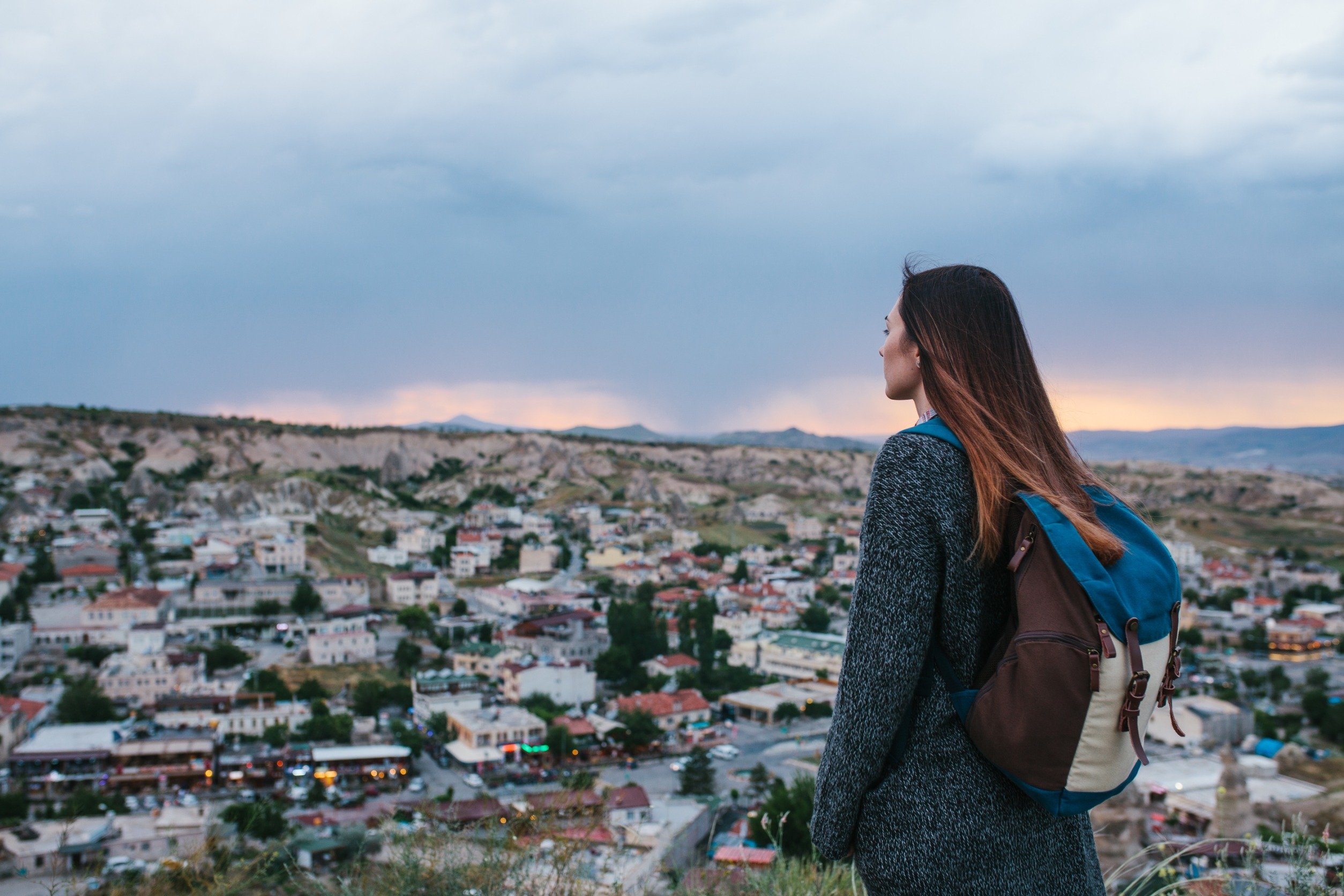 Young woman tourist from a high point looking at the sunset